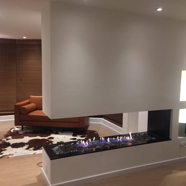 Chimenea lineal a gas de llama azul en sala de estar moderna